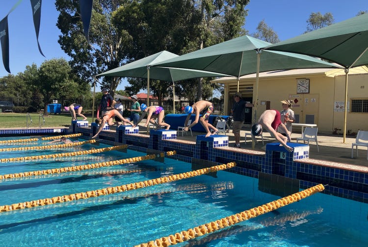 A male person is diving into a pool.